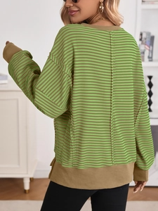 Back view of oversized striped sweatshirt featuring green and brown patchwork and drop shoulders