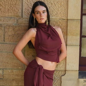 Detailed view of burgundy halter neck top with ruching and matching wrap skirt