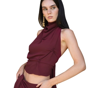 Detail of burgundy halter neck top featuring pleated chiffon fabric and elegant backless design