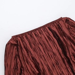 Gros plan sur un tissu plissé rouge rouille avec texture verticale et smocks élastiques