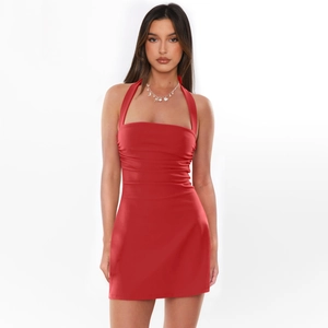 Détail d'une robe moulante rouge sexy avec licou attaché et finitions en satin plissé