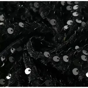 Close-up detail of high-quality black sequins sewn on thick velvet evening gown fabric