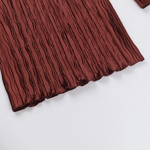 Gros plan sur un tissu plissé terracotta avec texture verticale et fini soyeux
