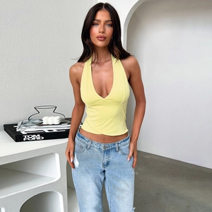 Detail of light yellow halter neck crop top with deep V-neckline and open back design