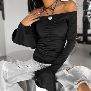 Detail of black off-shoulder top with smocked front and dramatic bell sleeve design