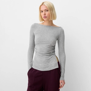 Detail of grey off-shoulder top featuring side ruched waist and asymmetric split hem
