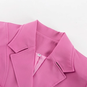 Close-up detail of pink notched lapel blazer featuring premium woven fabric and neat stitching