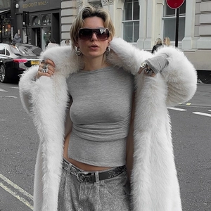 Chic long white faux fur coat paired with grey top and studded black leather belt