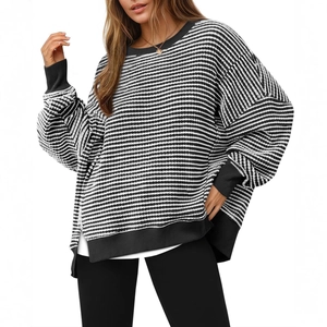 Women's oversized black and white striped knit sweater with round neck and side slits