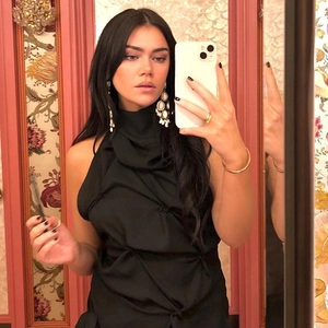 Detail of black halter top featuring handmade knotted pleats and chic neckline design