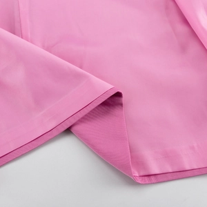 Detail shot of the pink suit fabric texture with fine stitched edges and tailored seams