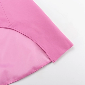 Detail of pink blazer suit showing clean stitching and plain weave fabric texture