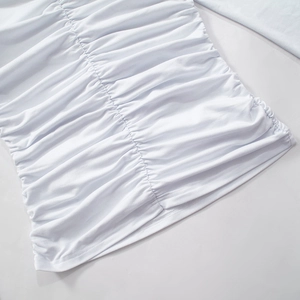 Detail shot of the white ruched fabric texture and elastic knitting on the off-shoulder top