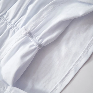 Close-up of overlock stitching and elastic tape detail on white off-shoulder top