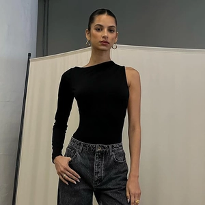Detail of slim fit one-shoulder long sleeve bodysuit paired with grey washed denim jeans