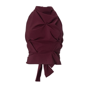 Detailed view of the pleated dark burgundy halter top with textured fabric and tie-up hem