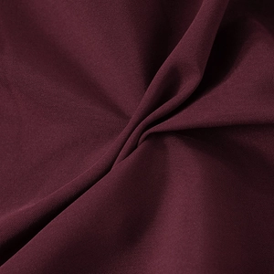 Macro texture of deep burgundy twill fabric showing fine weave and soft drape