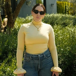 Detail of ruffled flared cuffs and ribbed texture on yellow slim-fit long-sleeved top