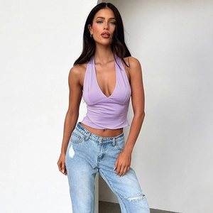 Close-up of a lilac halter neck top paired with light blue distressed denim jeans