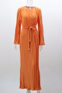 Detail view of the pleated orange maxi dress featuring long sleeves and tie waist belt