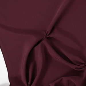 Close-up of burgundy fabric with elegant pleated center and gathered texture details