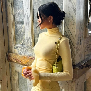 Macro view of high-density knit fabric and turtleneck collar of a slim fit yellow dress