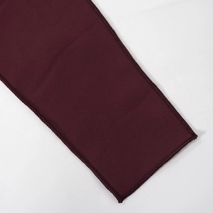 Close-up of wine red halter top fabric showing precise overlock stitching and texture