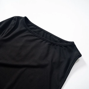 Detailed close-up of the black bodysuit's crew neck showing fine stitching and soft fabric