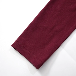 Detail of burgundy long sleeve cuff with double-needle stitching and knit texture