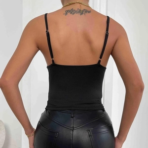Dettaglio di una canotta nera in maglia a coste con spalline regolabili e schiena scoperta