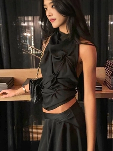 Chic black halter neck pleated crop top with matching mini skirt and chain handbag