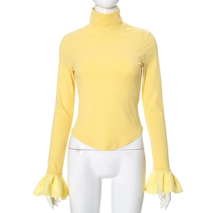 Close-up of light yellow ribbed knit top with ruffle cuffs and irregular V-hem details