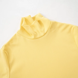Close-up of the light yellow ribbed knit fabric and high neckline detail of the top