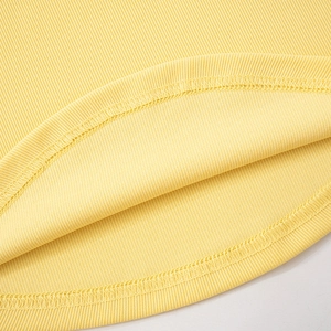 Detailed macro view of lemon yellow ribbed knit fabric showing hemline double stitching