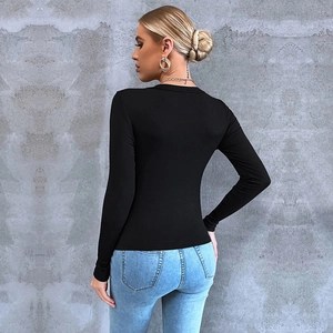 Dettaglio della trama in tessuto a coste nero e del design slim fit di una maglia a maniche lunghe