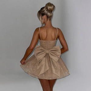 Detailed back view of a champagne sequin mini dress with an oversized statement bow
