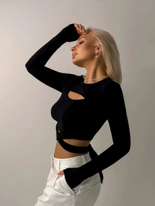 Nauwsluitende zwarte crop top met lange mouwen, uitsparing en duimgaten erin