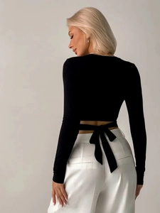 Nauwsluitende zwarte crop top met lange mouwen voor dames en een stijlvolle strik op de rug