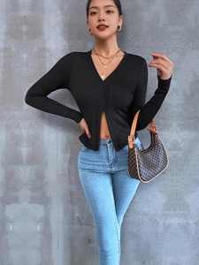 Top aderente nero a maniche lunghe con scollo a V e spacco frontale in elegante maglia a coste