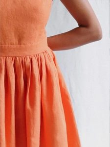 Detail of high-waist cotton mini dress featuring pleats and backless tie-up design
