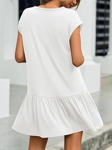 Détail de l'ourlet à volants et de la silhouette arrière d'une robe blanche évasée