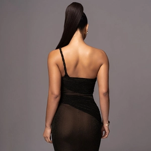 Detail of elegant black one-shoulder dress featuring sheer mesh panel and glitter finish