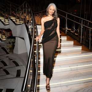 Detail of slim fit one-shoulder dress featuring sheer mesh panels and shimmering fabric
