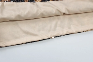 Detail of leopard print fabric featuring black sequins and beige smooth lining texture