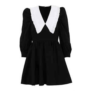 Detail of elegant white Peter Pan collar with delicate ruffles on black A-line dress