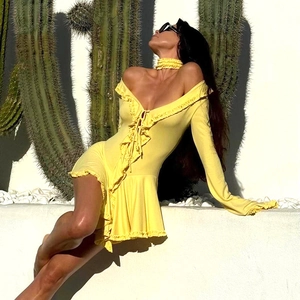 Detail of yellow long sleeve dress with ruffled edges and lace-up V-neckline