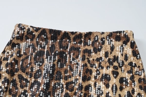 Detailed macro view of leopard print fabric with shimmering silver sequins on the surface