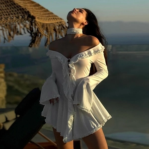 Detail of white long-sleeve dress with delicate ruffle edges and matching choker