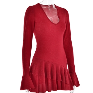 Détail d'une robe rouge à col en V profond avec tissu pailleté et ourlet à volants