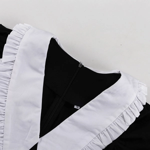 Detail of French black and white dress featuring a ruffled collar and back zipper